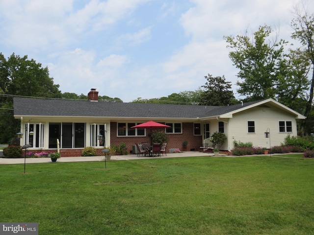 ranch-style house featuring a front lawn and a patio