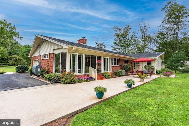 back of property with covered porch, a lawn, and a garage