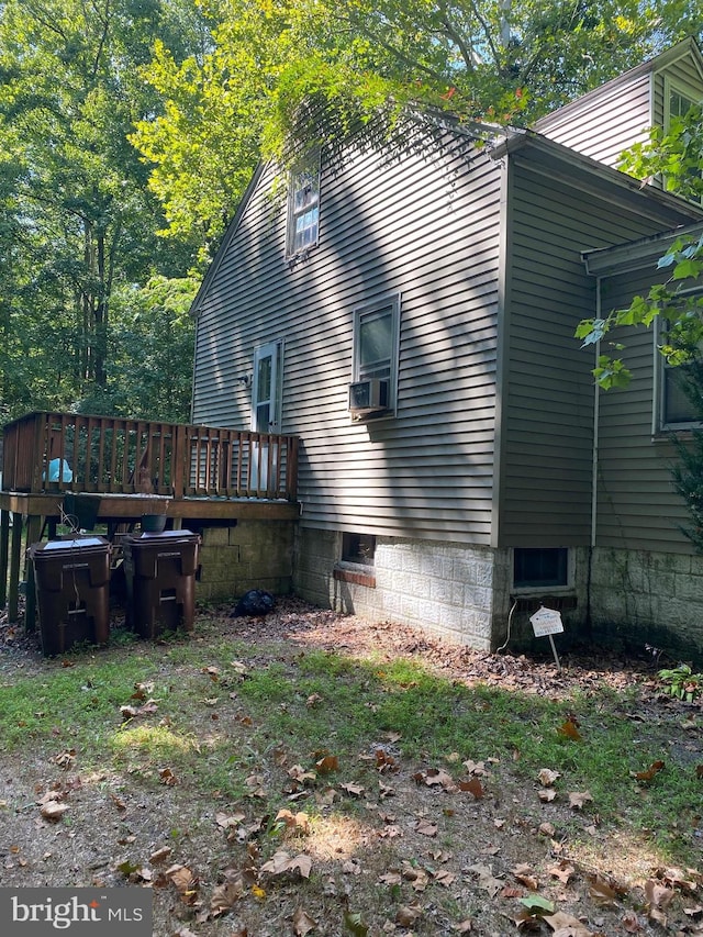 back of house featuring cooling unit and a wooden deck