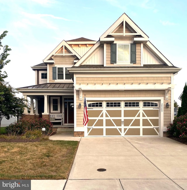 craftsman inspired home featuring a front lawn, a porch, and a garage