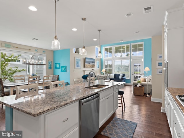 kitchen with a center island with sink, stainless steel dishwasher, dark wood-type flooring, and white cabinets