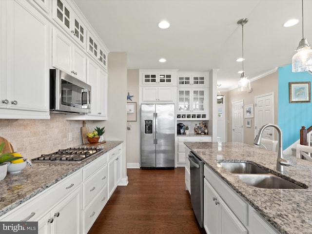 kitchen with white cabinets, appliances with stainless steel finishes, hanging light fixtures, and sink