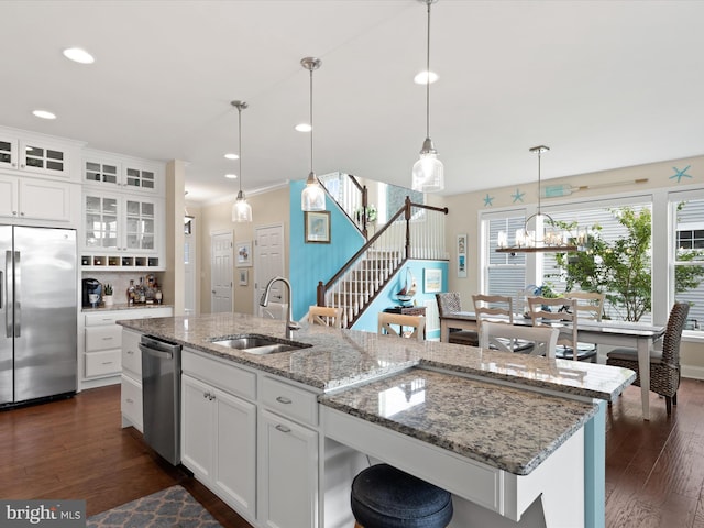 kitchen featuring a kitchen island with sink, stainless steel appliances, dark hardwood / wood-style flooring, and white cabinetry