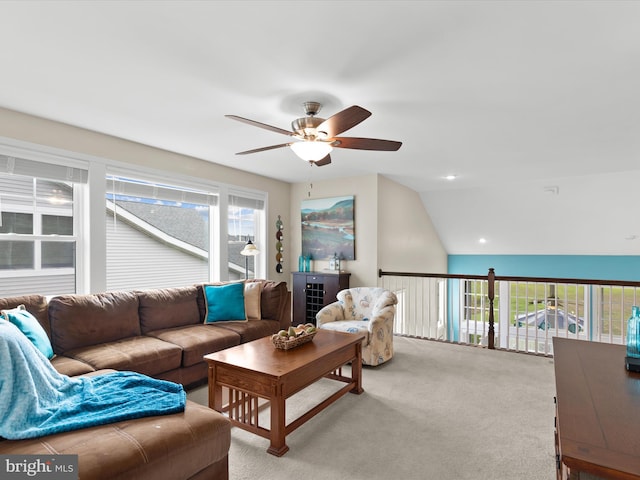 carpeted living room with lofted ceiling, ceiling fan, and a healthy amount of sunlight