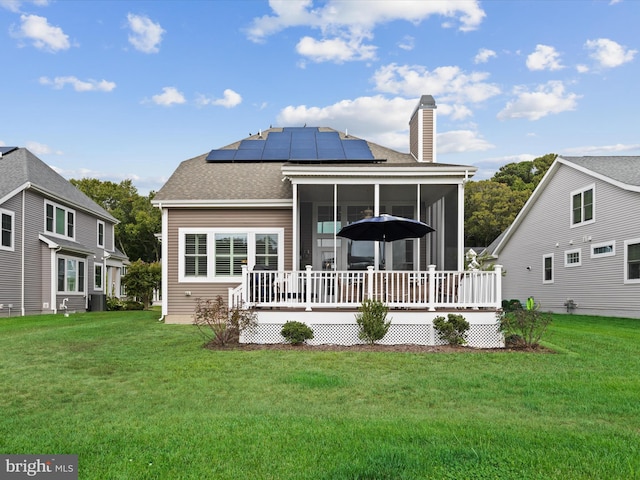 back of house with central air condition unit, solar panels, a yard, and a wooden deck