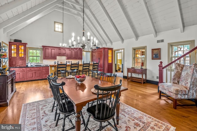 dining area with light hardwood / wood-style floors, a notable chandelier, and a healthy amount of sunlight