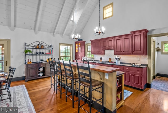 kitchen featuring a notable chandelier, light hardwood / wood-style flooring, a kitchen island, and stainless steel gas stovetop