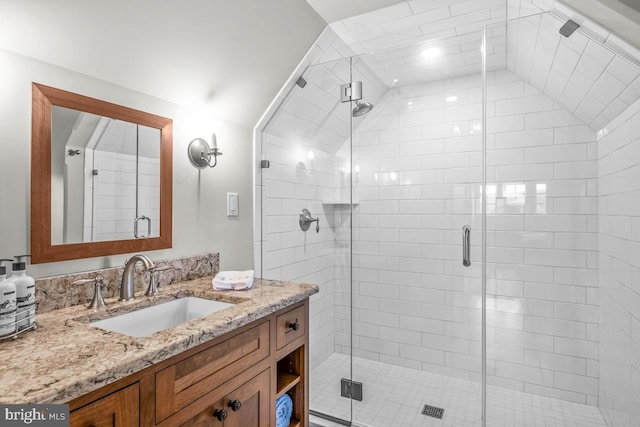 bathroom with vanity, vaulted ceiling, and a shower with shower door