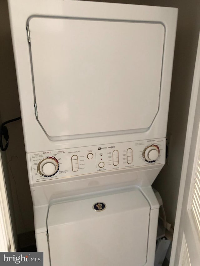 laundry area featuring stacked washer / dryer and laundry area