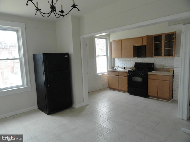 kitchen featuring black appliances, a healthy amount of sunlight, and light tile patterned floors