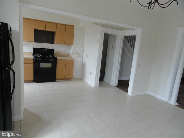 kitchen featuring decorative backsplash, light tile patterned floors, and black appliances