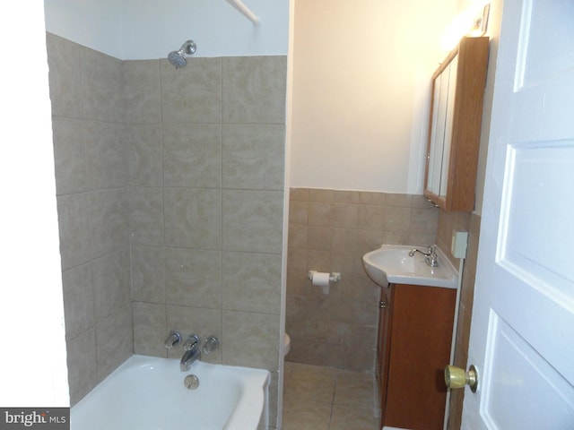 full bathroom featuring tile patterned floors, washtub / shower combination, vanity, tile walls, and toilet