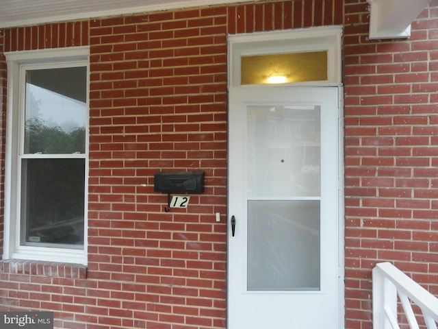 view of exterior entry featuring brick siding