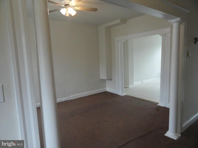 carpeted empty room featuring ceiling fan and decorative columns