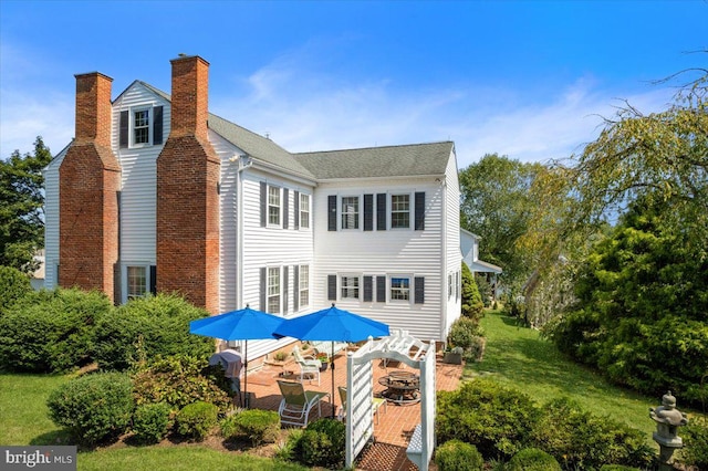 back of house with a patio area, an outdoor fire pit, and a yard