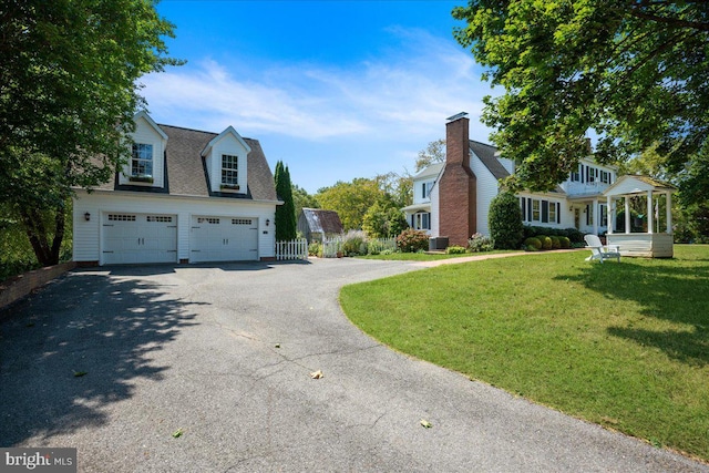 view of side of home featuring a lawn, a garage, and central air condition unit