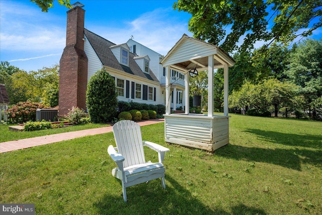 view of front of house featuring a front yard and central AC