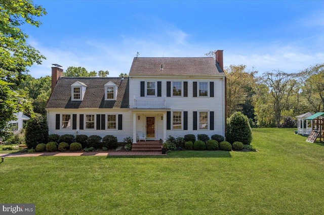 colonial-style house featuring a front yard