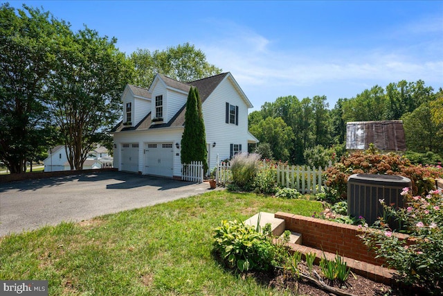 view of side of home with a garage and central AC unit