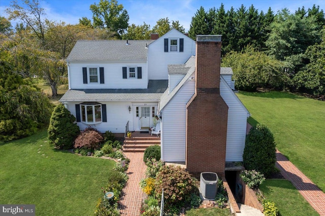 back of property with a lawn and central AC