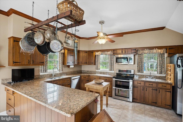 kitchen featuring lofted ceiling, kitchen peninsula, sink, and stainless steel appliances