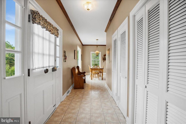 doorway featuring light tile patterned floors and crown molding