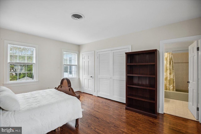 bedroom with dark hardwood / wood-style floors and ensuite bathroom