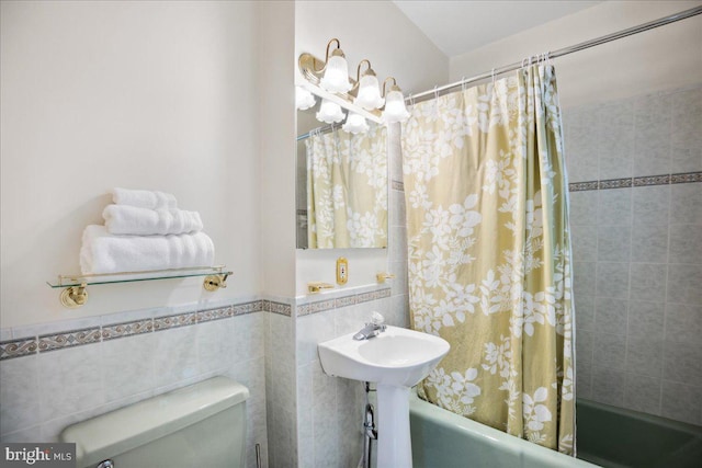 bathroom featuring tile walls, shower / bath combo with shower curtain, and toilet