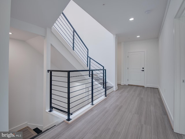 hall with light wood-type flooring and a skylight