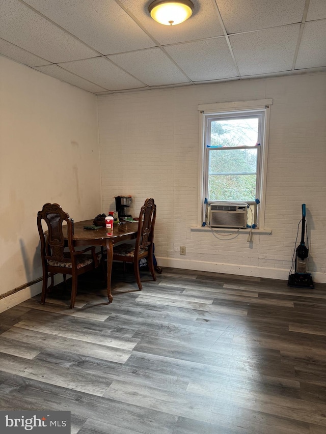 dining area with baseboards, a drop ceiling, cooling unit, and wood finished floors