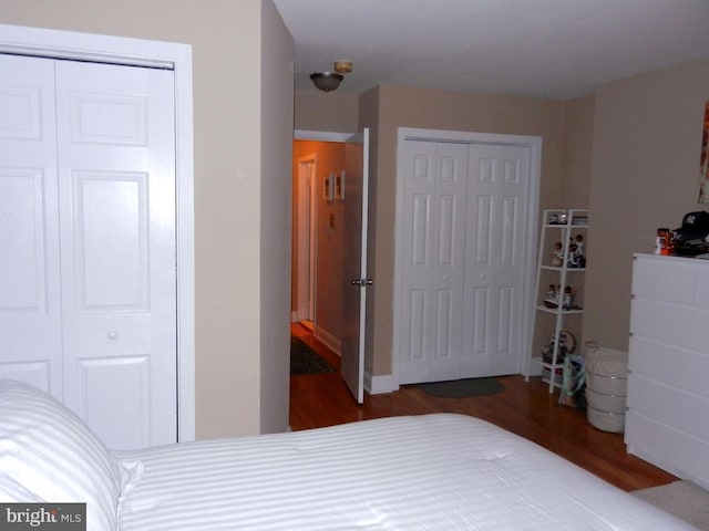 bedroom featuring hardwood / wood-style flooring and multiple closets