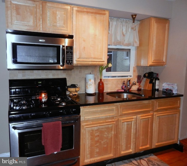 kitchen with appliances with stainless steel finishes, sink, dark wood-type flooring, and backsplash