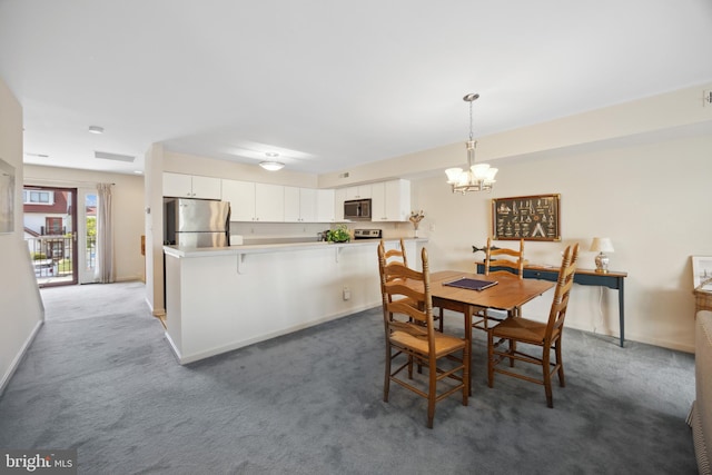 dining room with a notable chandelier and dark colored carpet