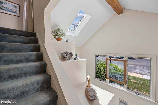 stairway with lofted ceiling with beams