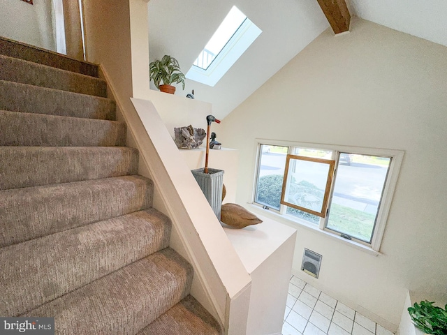 stairway with beam ceiling, high vaulted ceiling, tile patterned floors, and a skylight