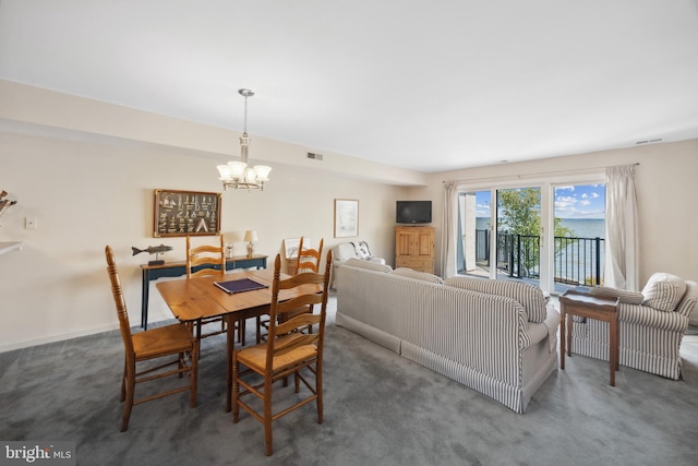 carpeted dining room featuring a chandelier