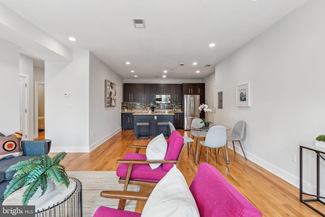 living room with light hardwood / wood-style flooring and electric panel