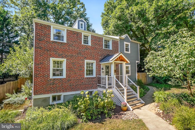 view of front of property featuring brick siding and fence