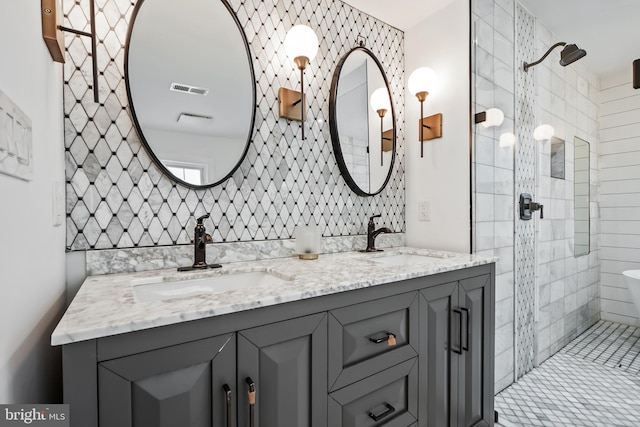 bathroom featuring a tile shower, tasteful backsplash, and vanity