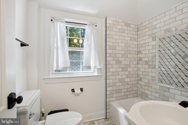 bathroom featuring toilet and tiled shower / bath