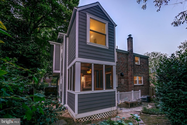 back house at dusk featuring central AC unit