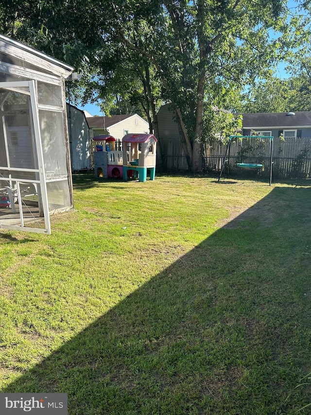 view of yard featuring fence and a playground