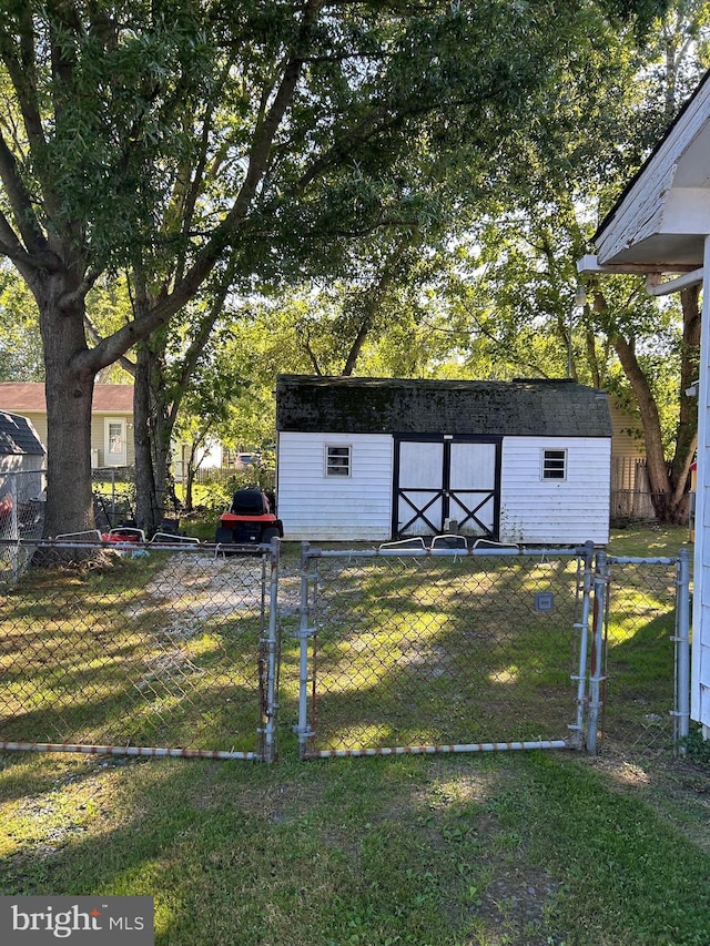 view of yard with an outbuilding, fence, and a gate