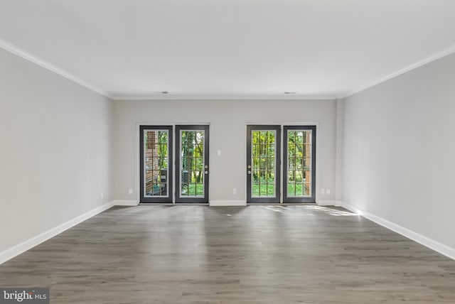 spare room with ornamental molding, a healthy amount of sunlight, and dark hardwood / wood-style floors