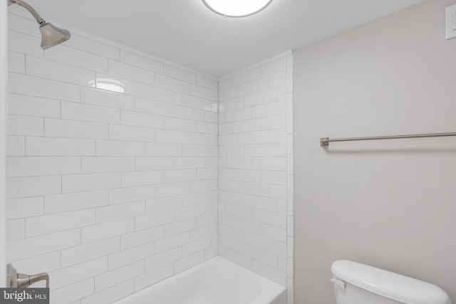 bathroom featuring toilet and tiled shower / bath combo