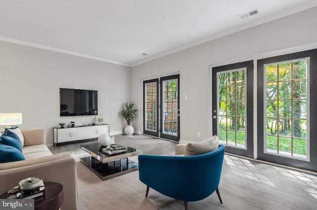 living room with ornamental molding, visible vents, and baseboards