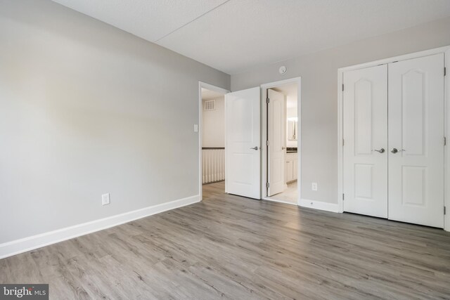 unfurnished bedroom with a closet and hardwood / wood-style flooring