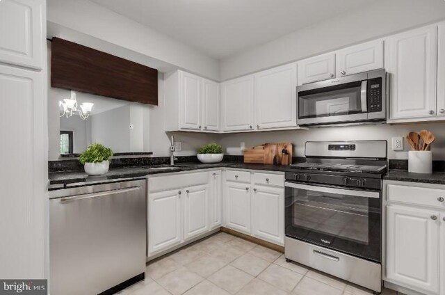 kitchen with white cabinets, stainless steel appliances, and light tile patterned flooring