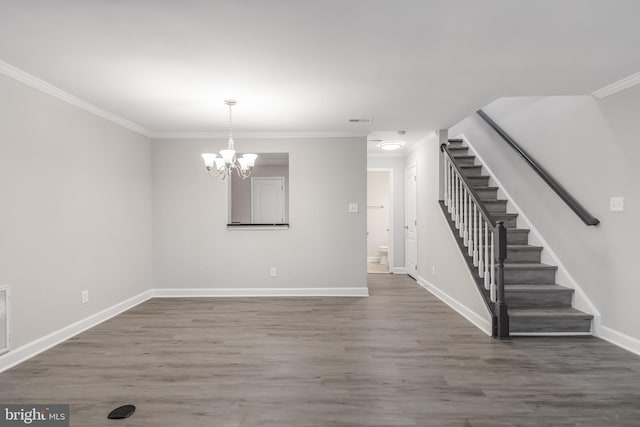 unfurnished dining area with crown molding, a notable chandelier, and hardwood / wood-style floors