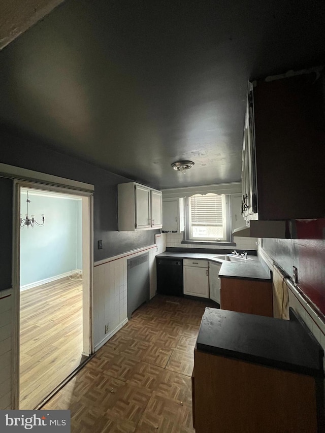 kitchen with white cabinetry, dishwasher, and sink